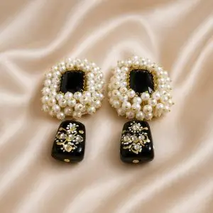 Royal Pearl & Black Stone Handmade Statement Earrings with pearl cluster design on a soft beige satin background.